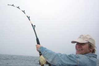 Kurtis taking turn reeling in blue fin tuna.